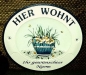 Preview: Keramik-Türschild mit Wunschtext – Relief mit blauem Rand – Blumenmotiv – 18 x 15,5 cm – Handarbeit – Restbestand