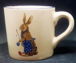 Keramik-Tasse  - Becher mit Wunschname – Motiv: 2 x Osterhase mit blauer Schürze